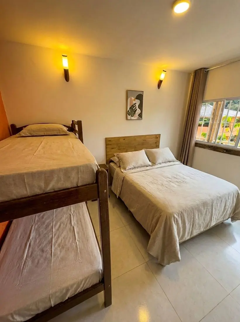 Suíte Coleirinha: cama de casal e beliche, com janela para a mata