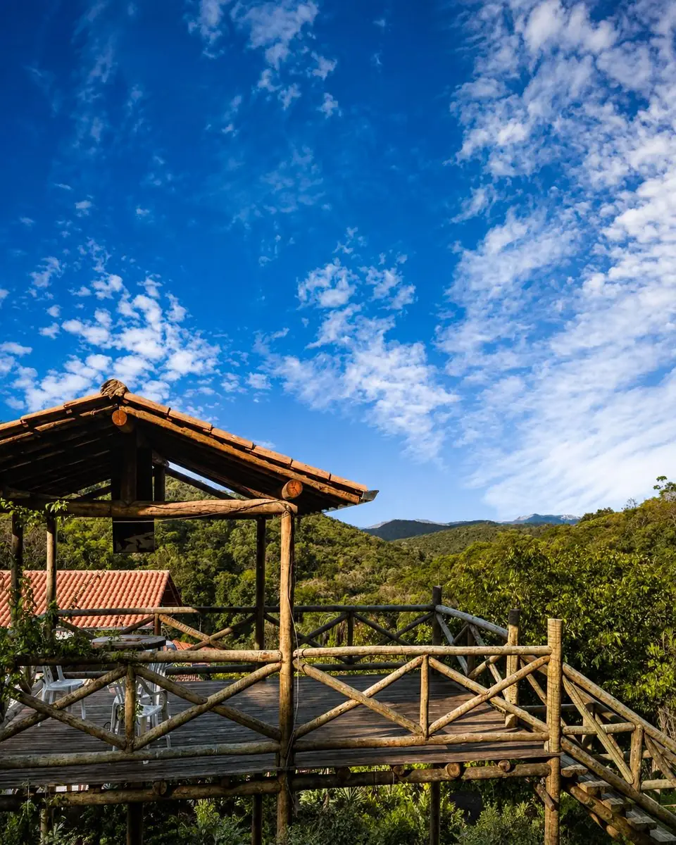 Deck de madeira do mirante, com a serra da Mata Atlântica ao fundo